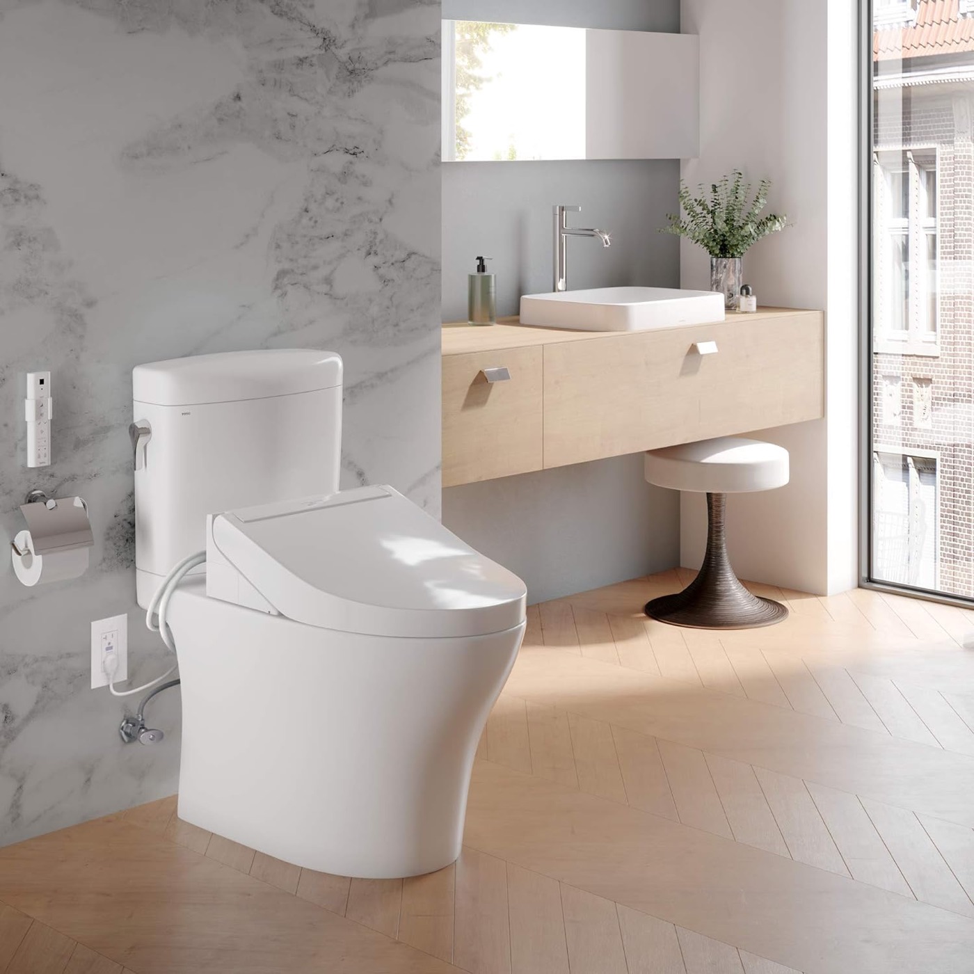 Toto washlet plugged into a wall outlet in a marble Utah bathroom